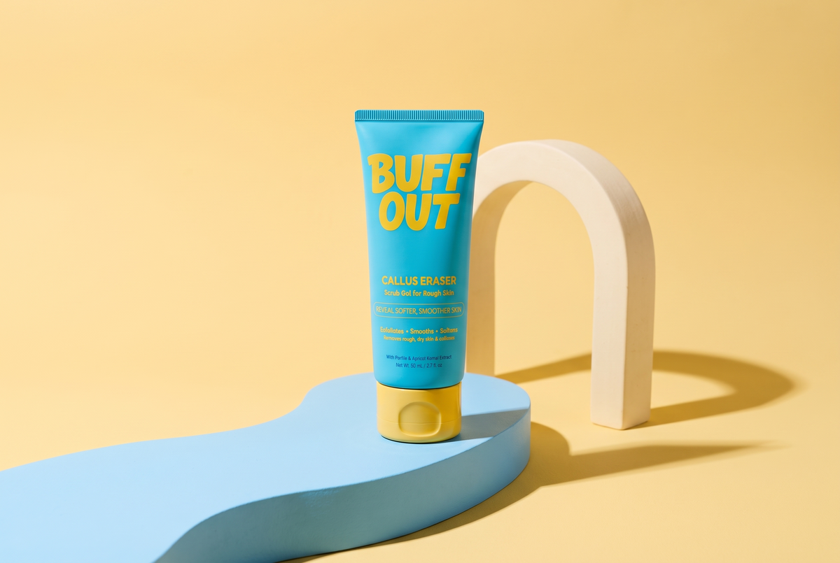 BuffOut tube on a blue sculptural platform with a yellow backdrop